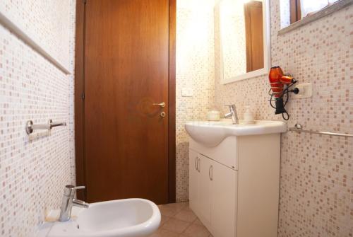 a bathroom with a sink and a toilet and a mirror at Appartamenti LEVANTE e LIBECCIO in Follonica