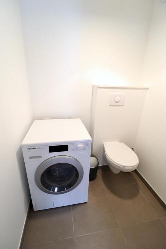 une machine à laver dans une salle de bain avec toilettes dans l'établissement Maison bleue - Apt 4 pers, 2 chambres, prox marché, à Le Touquet-Paris-Plage