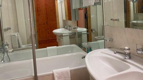 a bathroom with a sink and a bath tub and a sink at Paravicini 1 in St. Moritz