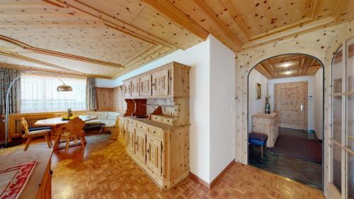 a kitchen with wooden cabinets and a dining room at Paravicini 1 in St. Moritz