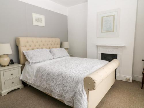 una camera bianca con letto e camino di Daisy Cottage a Bideford