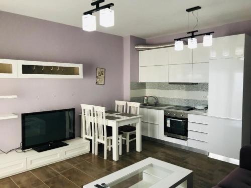 a living room with a table and a kitchen at Seaview Apartment in Dhërmi