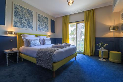 a bedroom with a large bed and a large window at Hôtel Petit Palais in Nice