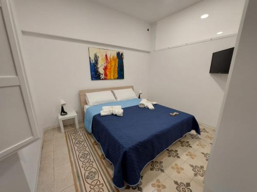 a bedroom with a blue bed with towels on it at Al cortiletto in Castellammare del Golfo