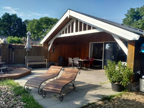 Volkel的住宿－Chalet "Het Biggetje" met hottub，带顶棚、两把椅子和一张桌子的庭院