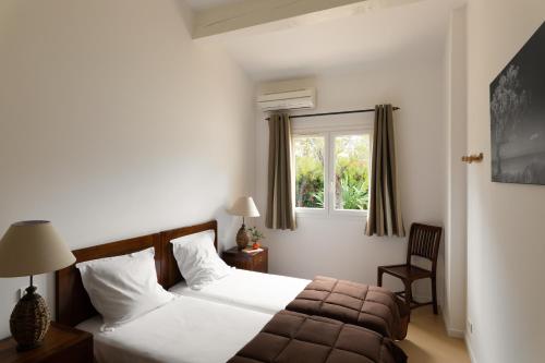 um quarto de hotel com uma cama e uma janela em Résidence Marina Rossa em Porto-Vecchio