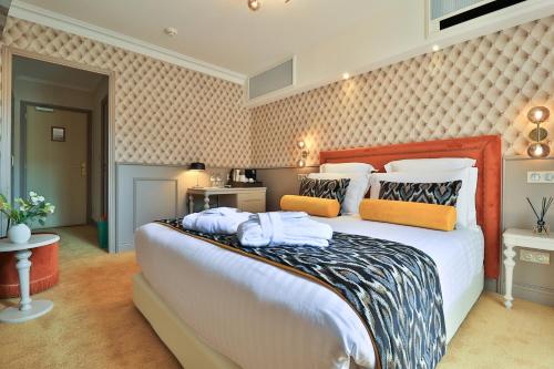 a bedroom with a large bed with towels on it at Hôtel Petit Palais in Nice