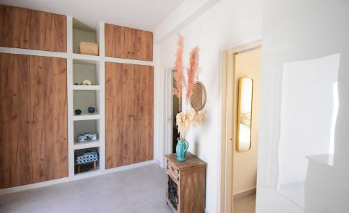 a hallway with wooden cabinets and a vase of flowers on a table at Nesea in Psérimos