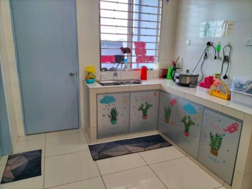 a kitchen with a counter with cactus drawings on it at Sekinchan 2008 Home：Karaoke/BBQ in Sekinchan