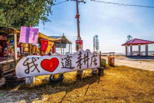 a sign with graffiti on it next to the beach at Sekinchan 2008 Home：Karaoke/BBQ in Sekincan