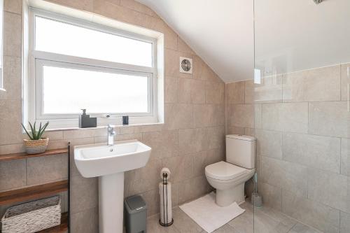 a bathroom with a toilet and a sink and a window at Kingsway Property in Goole