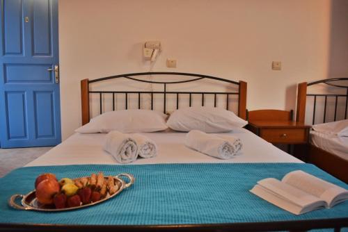 a bed with a tray of food on it at Amodari studios on the beach in Plaka