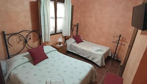 sypialnia z 2 łóżkami, oknem i telewizorem w obiekcie Casa Rural Aguascebas w mieście Mogón