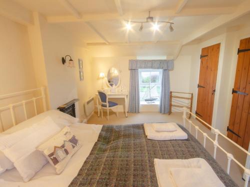 a bedroom with a large bed and a desk at Bwthyn Gynon in Goodwick