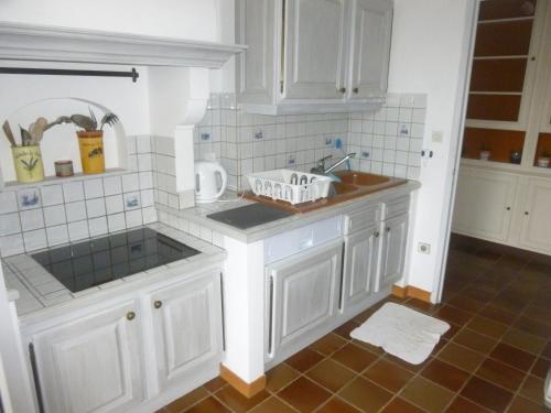 une cuisine avec des armoires blanches et un évier dans l'établissement SANARY - Zone piétonne - CLIM - 2 chambres 4 à 6 personnes - WIFI, à Sanary-sur-Mer
