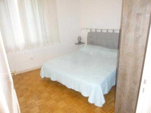 une chambre avec un lit avec un couvre-lit blanc dans l'établissement SANARY - Zone piétonne - CLIM - 2 chambres 4 à 6 personnes - WIFI, à Sanary-sur-Mer