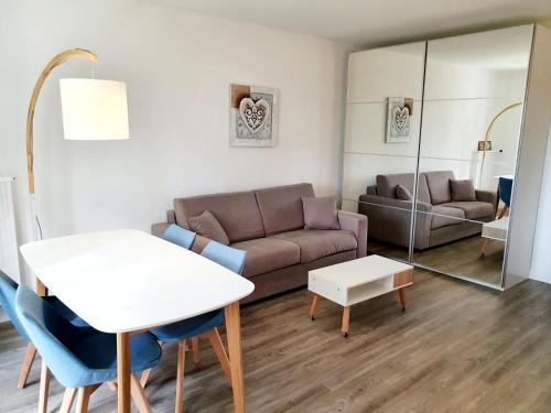 a living room with a couch and a table at Le bord de plage in Bénerville-sur-Mer