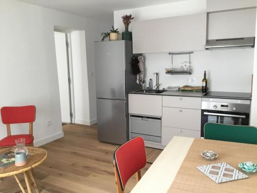 a kitchen with white cabinets and a table and chairs at Verdun 2 in La Rochelle