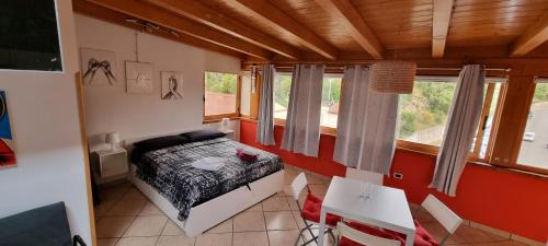 Schlafzimmer mit einem Bett, einem Tisch und Fenstern in der Unterkunft House center Licia in Capo dʼOrlando