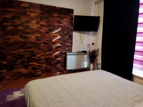um quarto com uma cama e uma parede de tijolos em Lara em Doboj