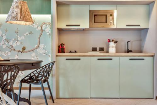 uma cozinha com armários brancos e uma mesa em Magnolia, Terre Marine em Lerici