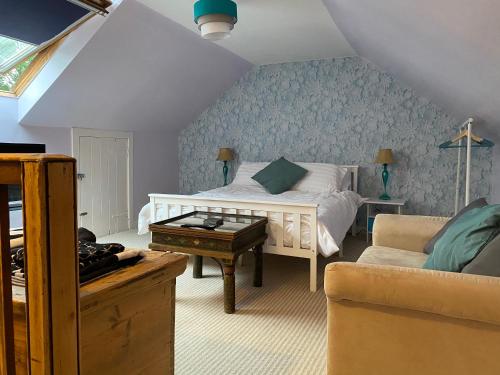 um quarto com uma cama, uma mesa e um sofá em Jack’s Roost em Clovenfords