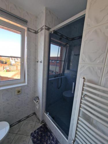 a bathroom with a shower with a glass door at Apartament Hexagon nr 17 in Grzybowo