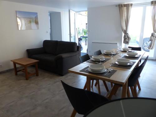 un salon avec une table et des chaises en bois dans l'établissement La nuit des Planeurs, à Vierville