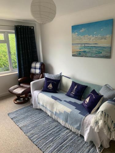 a bedroom with a bed with purple pillows at Lovely well equipped apartment - 2 bedroom, sleeps 4, sundeck, 8 min river walk to beach and town, FREE parking permit ! in Lyme Regis