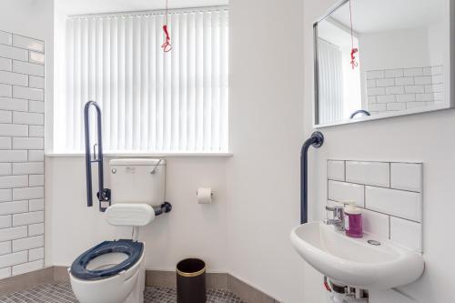 a bathroom with a toilet and a sink and a mirror at Dusties Hotel in Rotherham