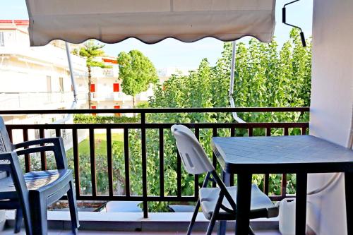 a table and two chairs on a balcony with a table and an umbrella at Το Κοράλι in Amarinthos