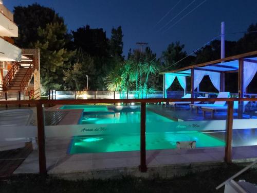 a swimming pool at night with blue lights at Arena de mar depto K in Mar de las Pampas