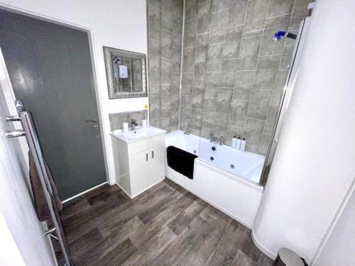a bathroom with a tub and a sink and a shower at Reads Jacuzzi Suites & Apartments in Blackpool