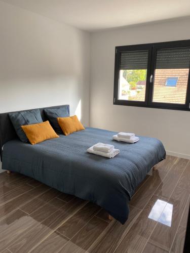 ein Schlafzimmer mit einem blauen Bett mit zwei Handtüchern darauf in der Unterkunft Villa St Julien 10 mn de Dijon in Saint-Julien
