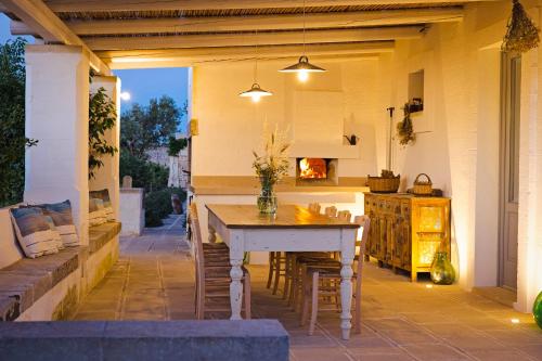 a patio with a table and chairs and a kitchen at Masseria Ferarelli Trepizzi in Diso