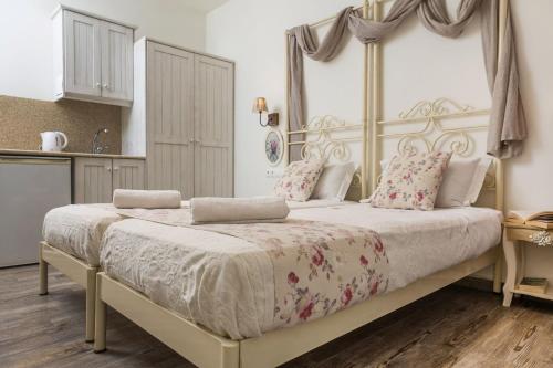 a bedroom with a large white bed with flowers on it at Naxos Petite Studios in Agios Prokopios