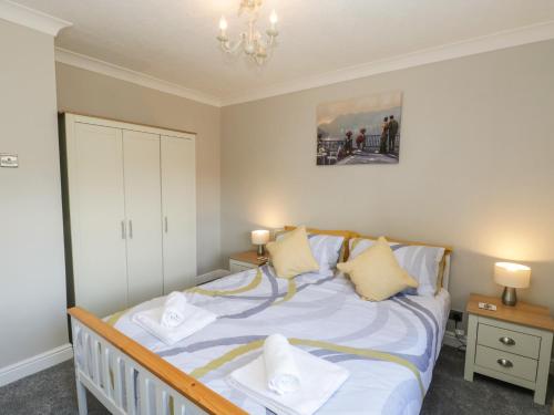 a bedroom with a bed with white sheets and pillows at Rose Bungalow in Whitby