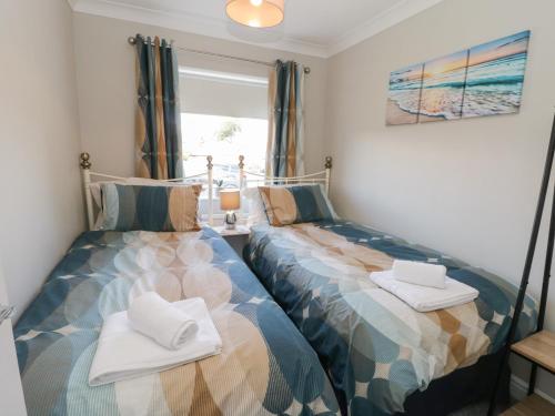 two beds sitting next to each other in a bedroom at Rose Bungalow in Whitby