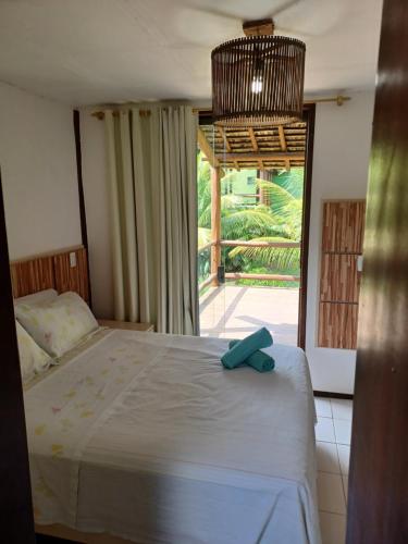 a bedroom with a bed and a large window at Bangalô duplex à beira-mar in Camaçari
