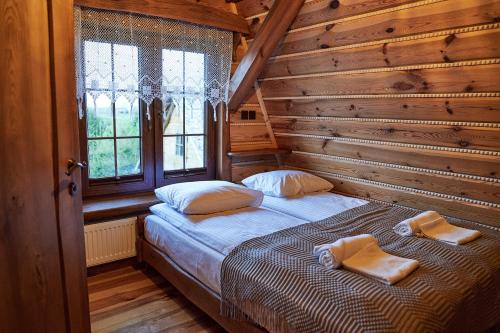 a bedroom with a bed in a log cabin at Siedlisko Sodyba in Puńsk