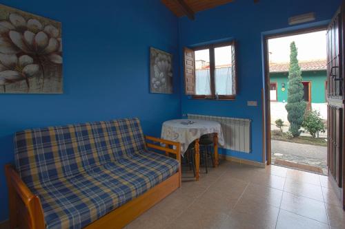 a room with a table and a couch and a table at Apartamentos El Campal in Felechosa