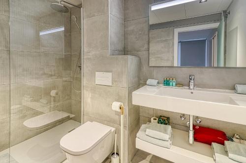 a bathroom with a toilet and a sink and a mirror at Alse Homes Adeje Plaza in Adeje