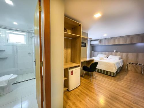 - une chambre avec un lit et une salle de bains pourvue d'une douche dans l'établissement Pousada Viena, à Gramado