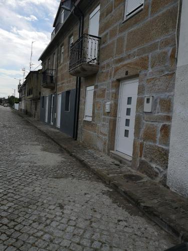 un bâtiment en briques avec une porte blanche dans une rue dans l'établissement 5 Cinco, à Chaves