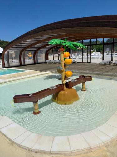 a fountain with an umbrella and a bench in the water at Le mobilhome de Evelyne et Serge in Lit-et-Mixe