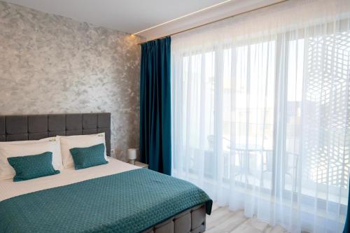 1 dormitorio con cama y ventana grande en Bel Air Mamaia Nord Complex - Apartament Delux, en Mamaia
