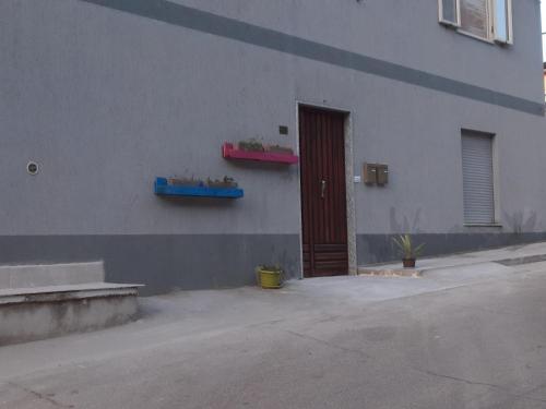 ein Gebäude mit einer braunen Tür und einem Fenster in der Unterkunft ALBA MOZZAFIATO in Lanusei