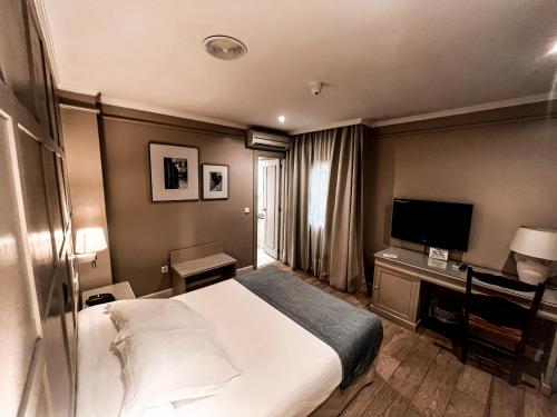 a hotel room with a bed and a television at Hotel Doña Blanca in Jerez de la Frontera