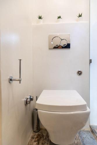 a bathroom with a toilet with two olympics on the wall at Naxos Petite Studios in Agios Prokopios