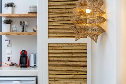 a kitchen with a wooden door with a chandelier at Naxos Petite Studios in Agios Prokopios